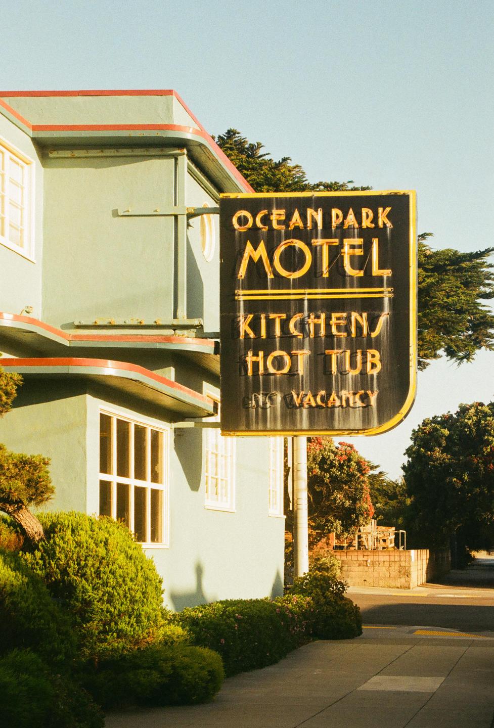 A vintage motel sign for Ocean Park Motel is visible next to a light green building with red trim.