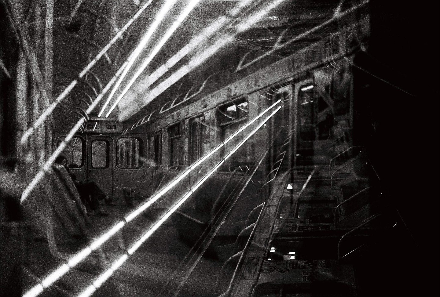 Bright light streaks cross the interior of a subway car where a person is seated.