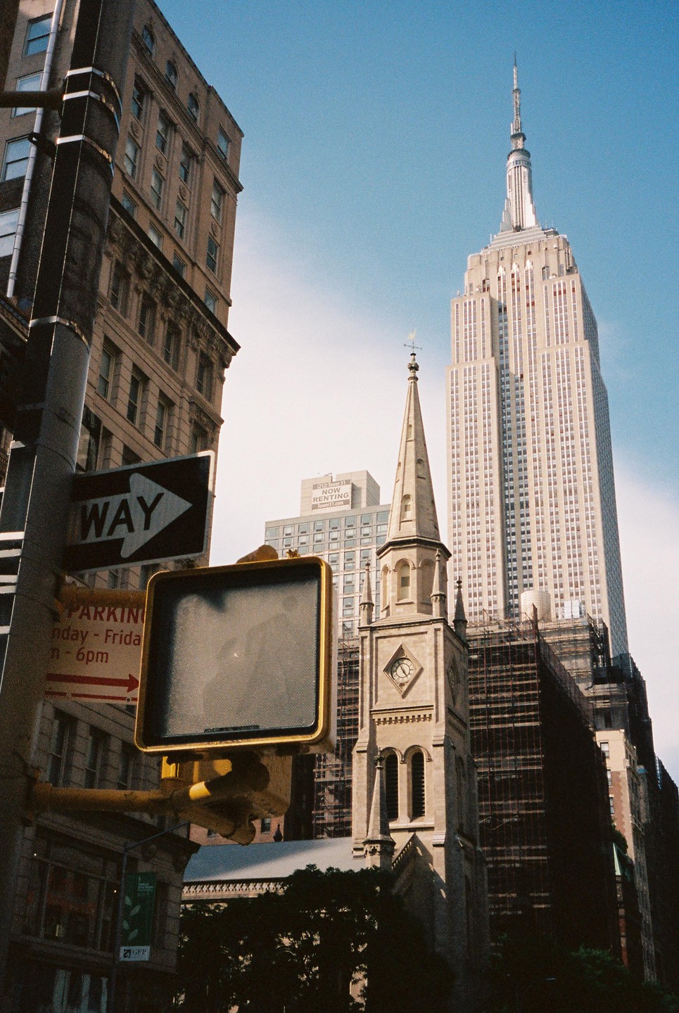 A street view of the Empire State Building and a church steeple in New York.