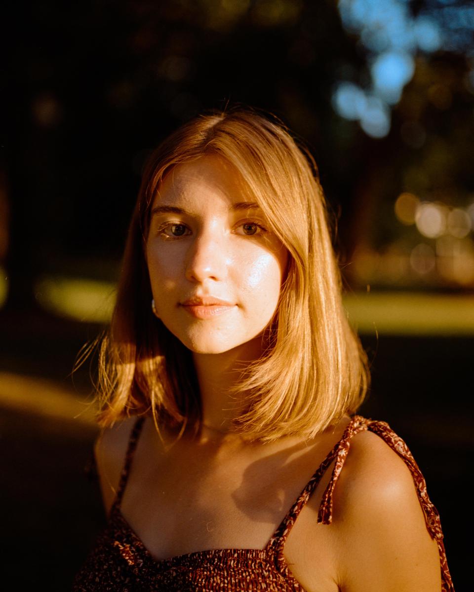 A woman with shoulder-length hair looks directly at the viewer.