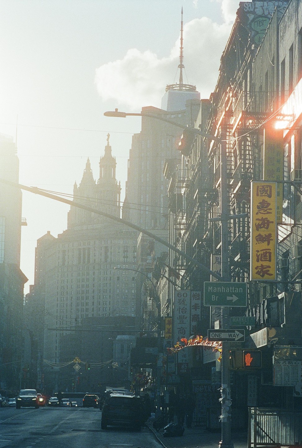 A street in New York City is filled with cars and buildings under a hazy sky.