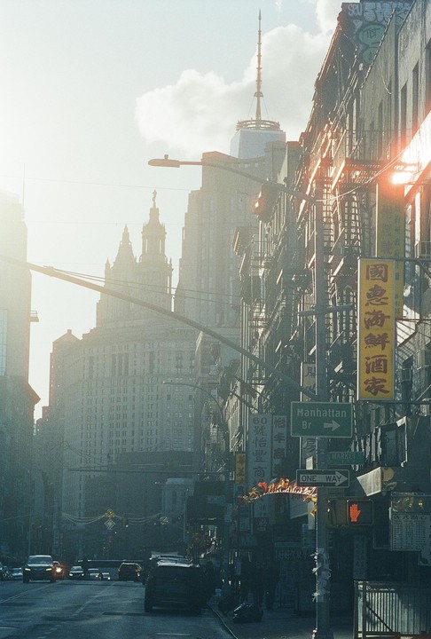 A street in New York City is filled with cars and buildings under a hazy sky.